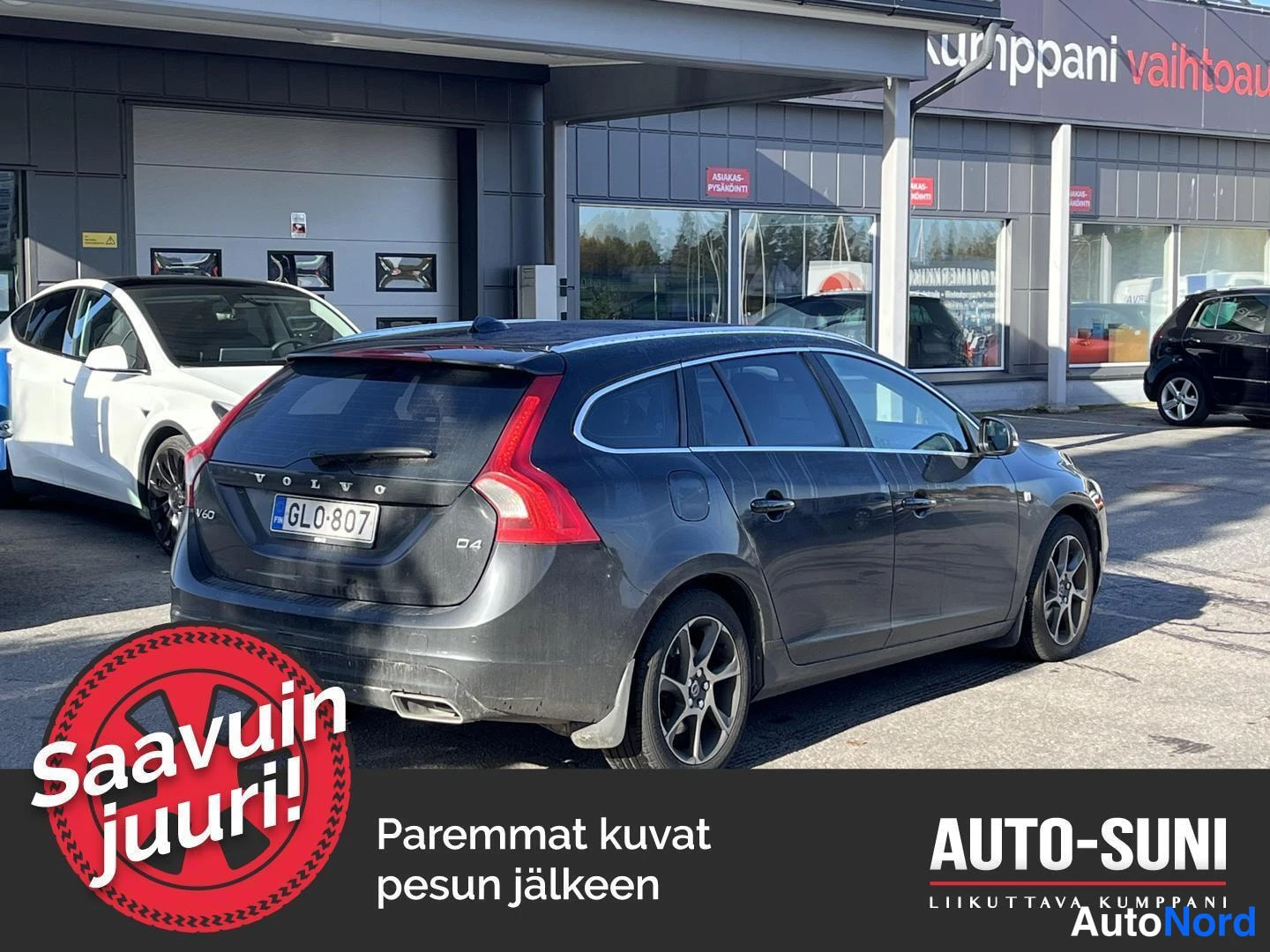 Takaviisto: Volvo V60 -farmari takaa ja sivulta, tummanharmaa, rekisteritunnus GL0-807, AUTO-SUNI-taloympäristössä.