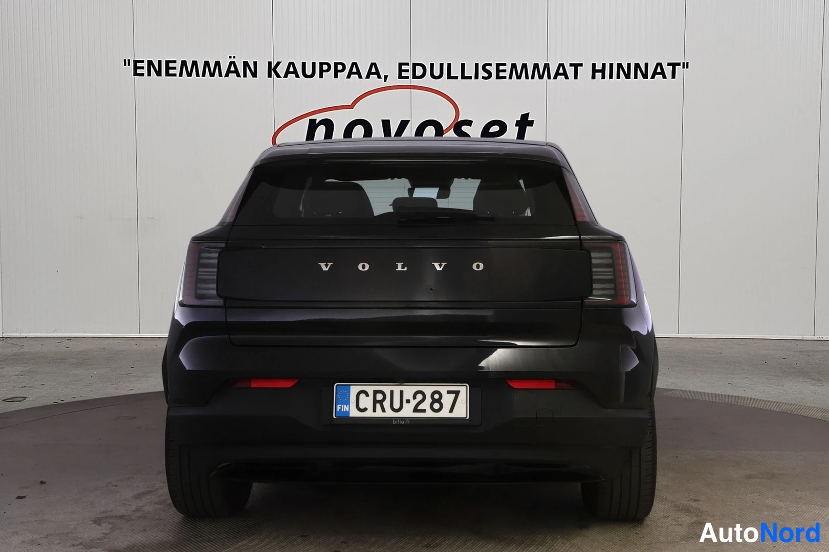 Takaa: Mustan Volvo EX30:n suora takanäkymä, VOLVO-teksti rekisterikilven yläpuolella, tunnus.
