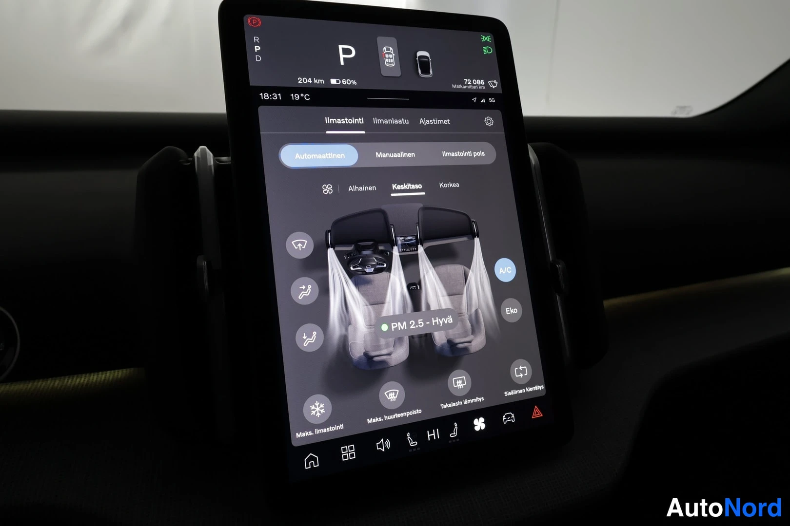 Edestä: Auton keskirivin infotainment-näyttö ilmastointinäkymässä: automaattinen ilmastointi, PM 2.5 -arvo Hyvä, A/C ja Eko-painikkeet näkyvissä.