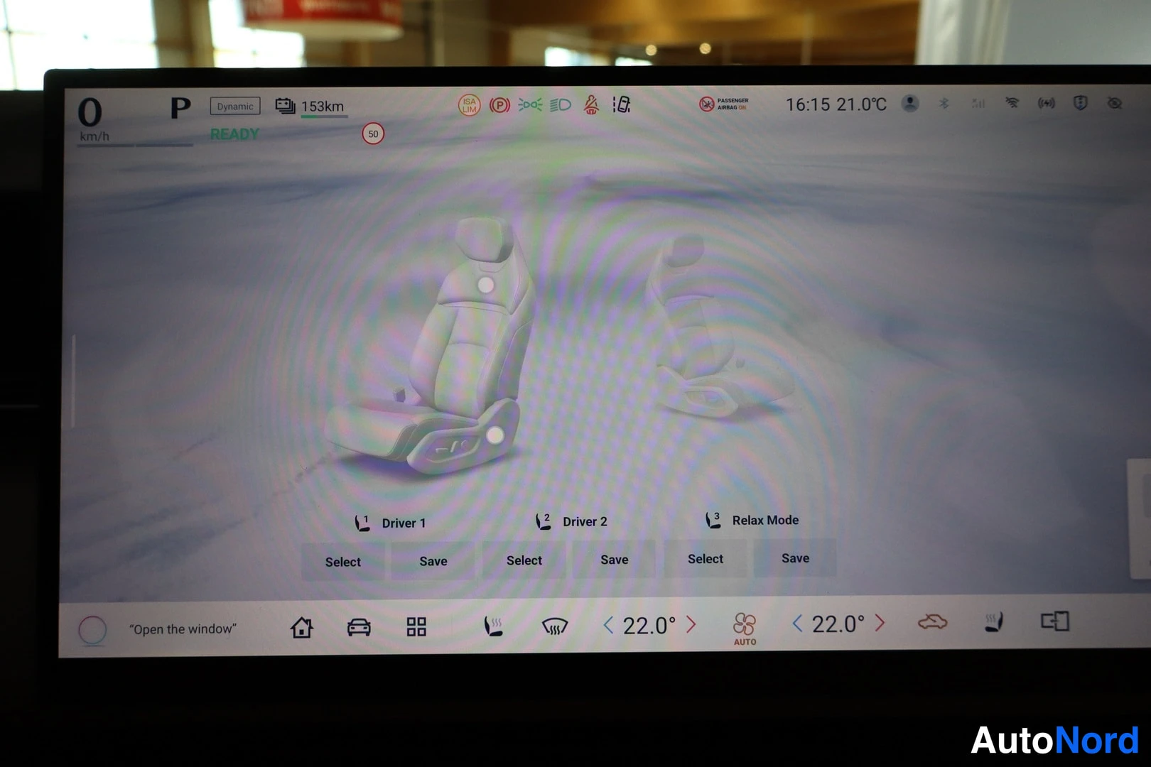 Muu: Auton infotainment-näyttö näkyy istuinten säätövalikossa, jossa on Driver 1, Driver 2 ja Relax Mode -profiilit Select- ja Save-painikkeineen. Yläpalkissa näkyvä