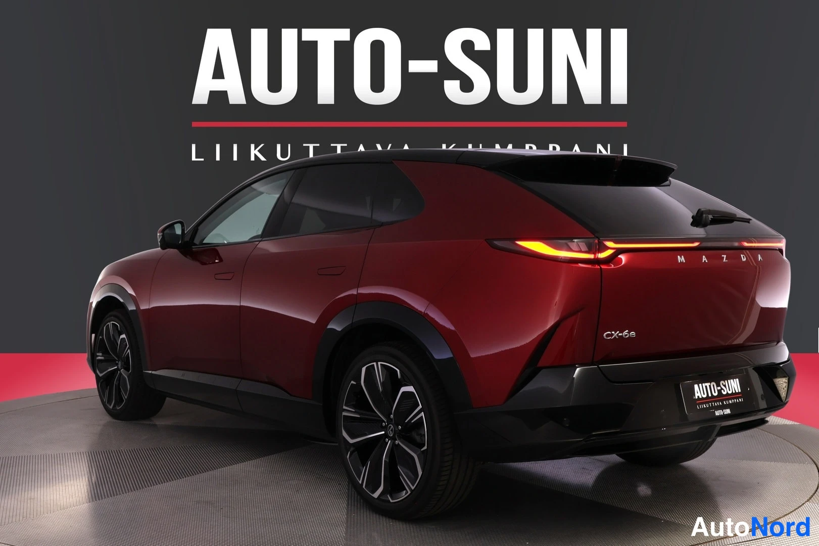 Takaviisto: Punainen Mazda CX-60 takaviistosta oikealle, CX-6e-merkintä ja Auto-Suni-logo takapuskurissa.
