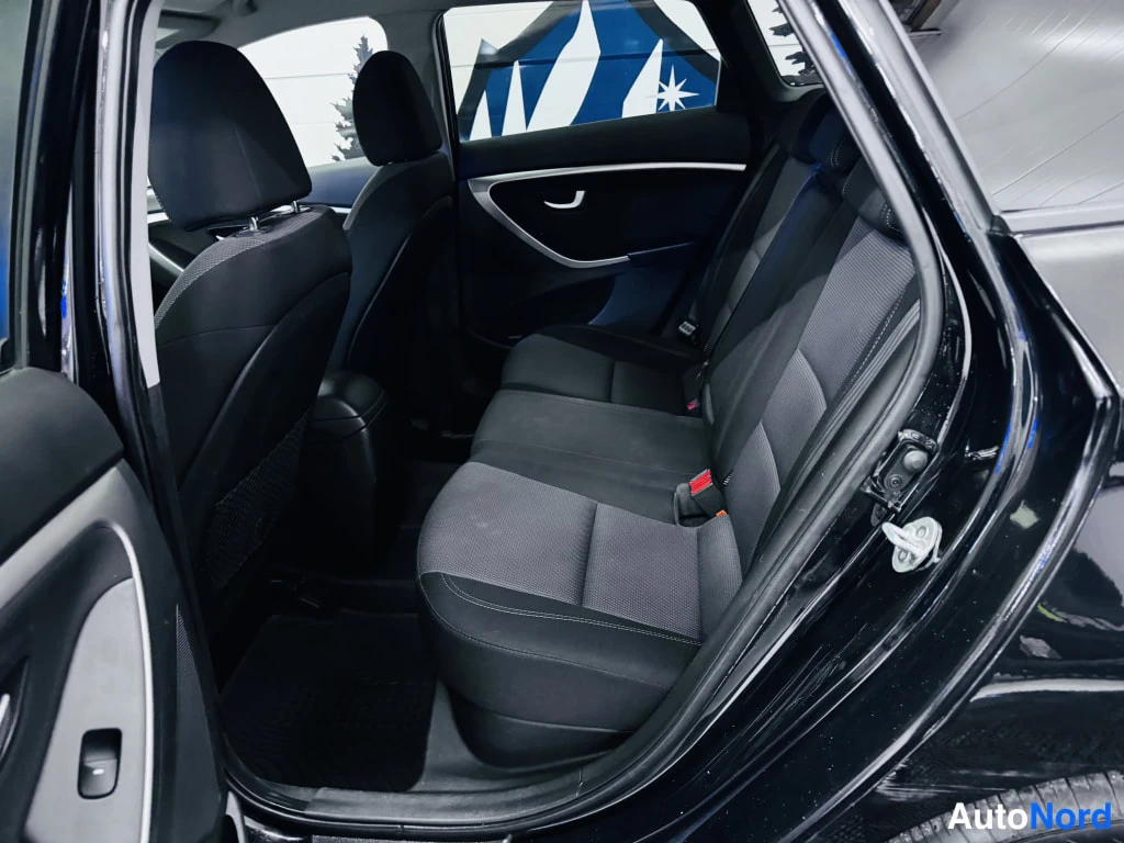 Takaistuimet: Hyundai i30:n takaistuin sisätiloissa; tummaa kangasverhoilua ja ISOFIX-kiinnikkeiden punaiset soljet.