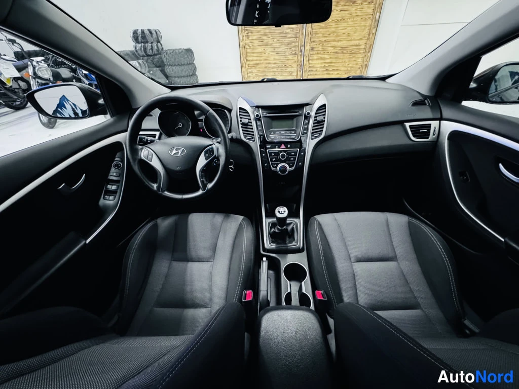 Yksityiskohta: Hyundai i30:n ohjaamo etualalta; manuaali vaihtajanuppi, monitoimiohjauspyörä ja radiopaneeli näkyvät.