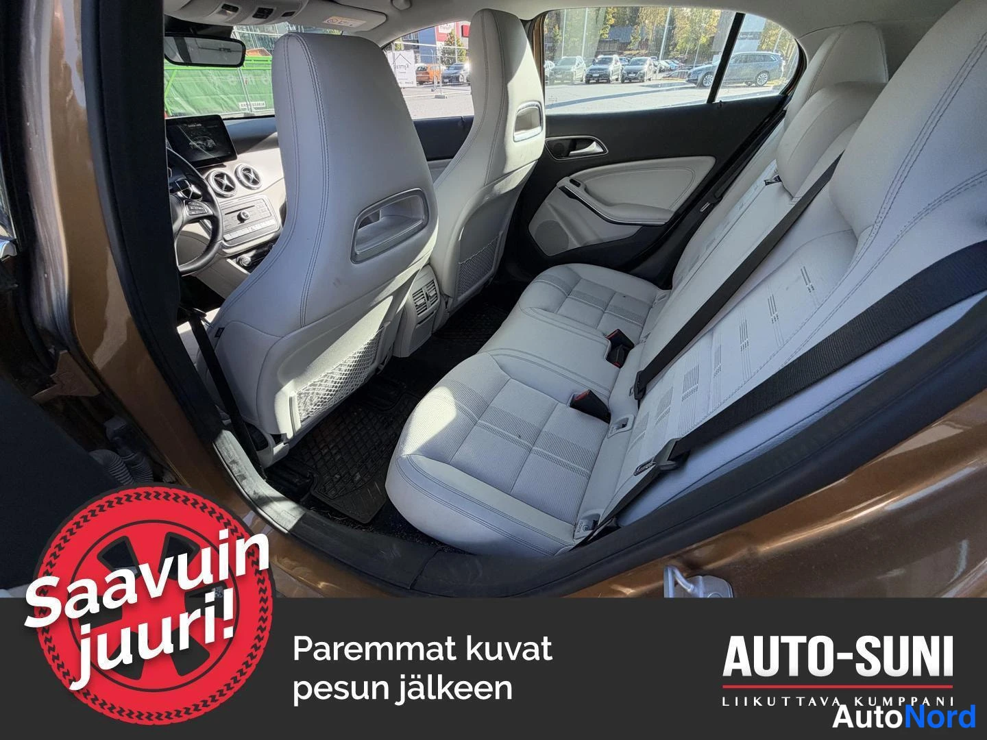 Takaviisto: Takaistuimen ja etupenkin näkymä autosta, penkit vaalealla verhoilulla; takaa auki oleva oikeanpuoleinen takaovi.