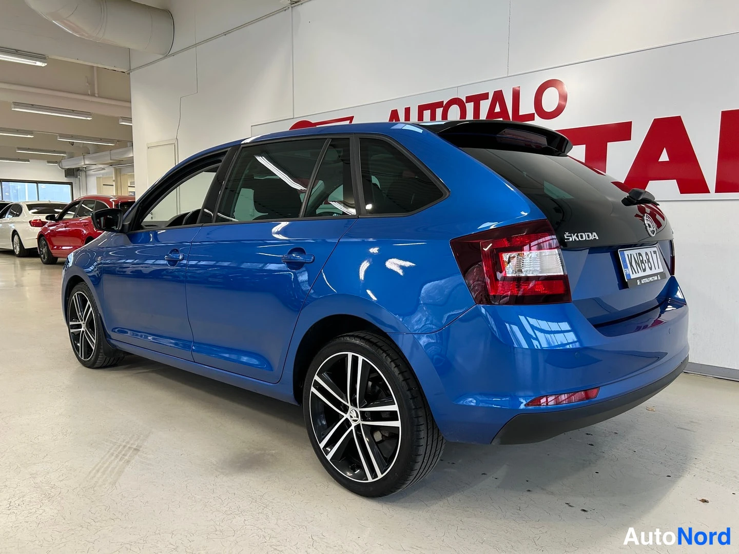 Takaviisto: Sininen Skoda Rapid takaviistosta vasemmalta, rekisterikilpi