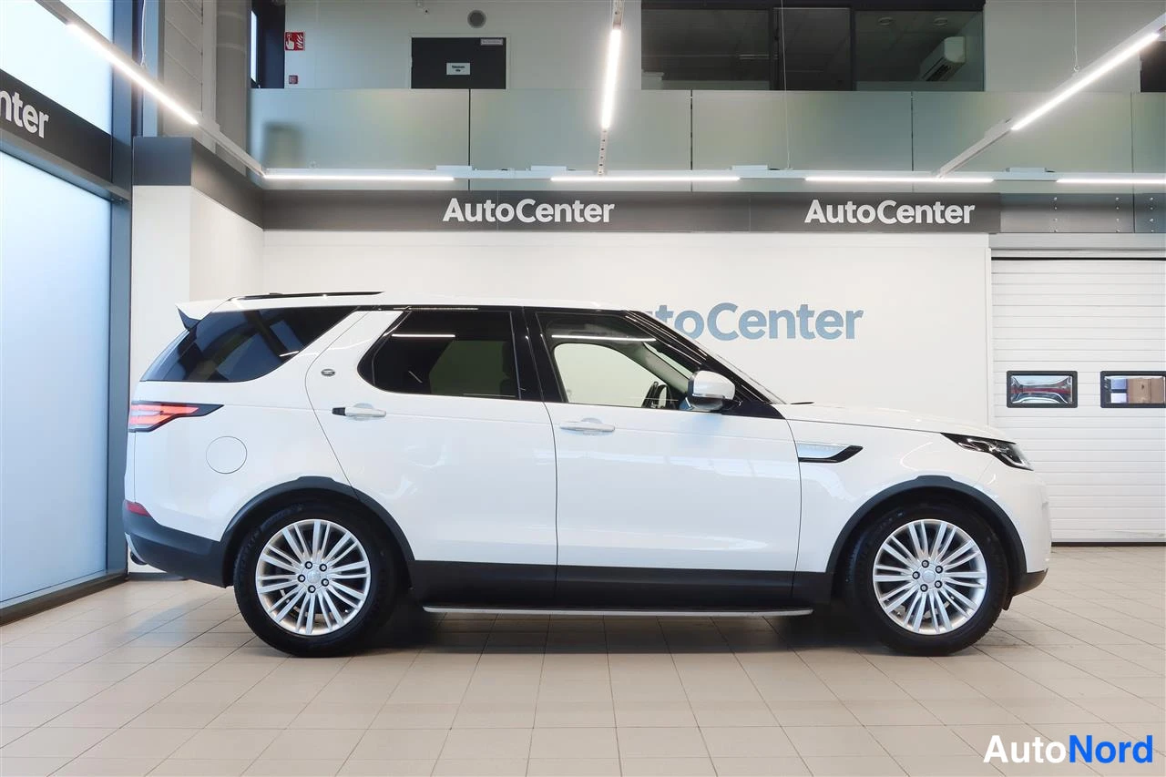 Sivulta: Valkoisen Land Rover Discoveryn sivuprofiili AutoCenter-hallissa.