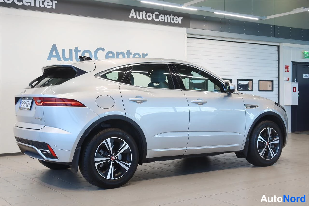 Takaviisto: Hopeanvärinen Jaguar E-PACE takakulmat näkymä sisätiloissa AutoCenter-tilassa, rekisteritunnus.