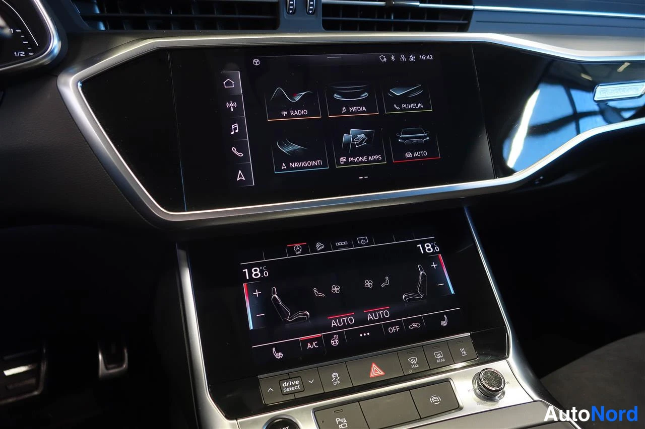 Muu: Audiin sisäistilanne: yläosassa infotainment-näyttö valikoilla Radio, Media, Puhelin, Navigointi ja Auto, alaosassa kaksivyöhykeilmastointipaneeli 18 °C:n asetu