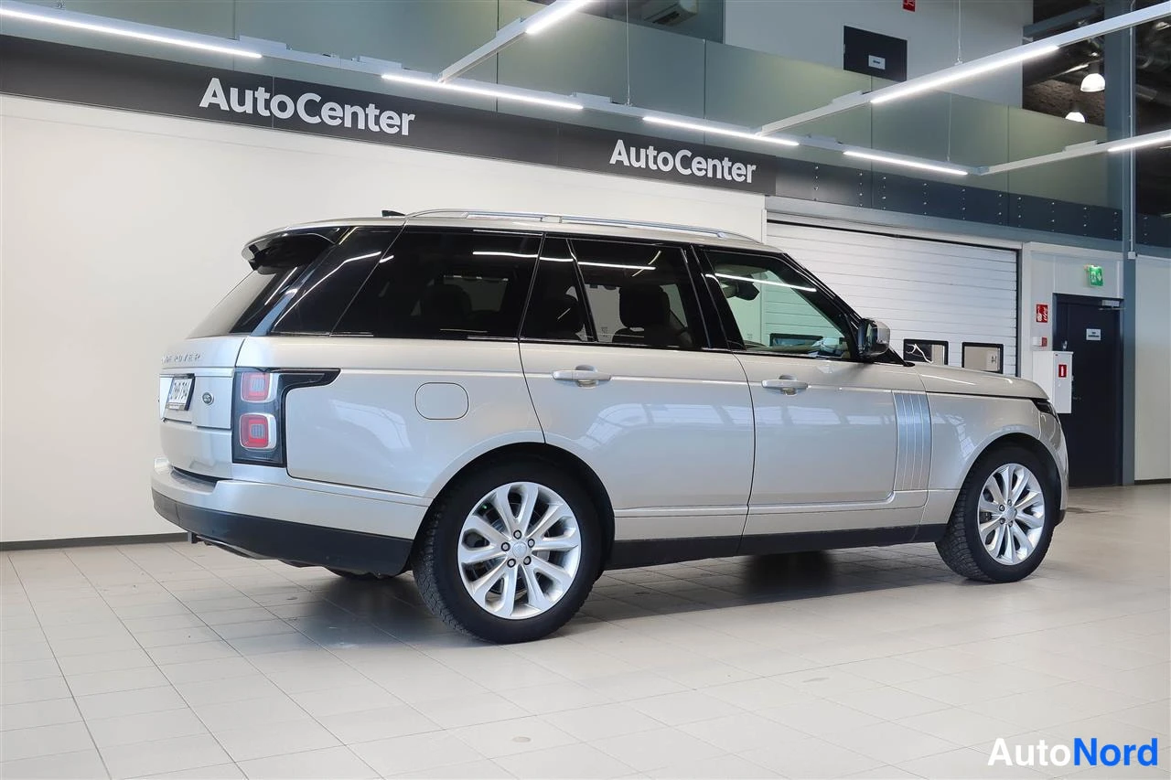 Takaviisto: Hopeanvärinen Land Rover Range Rover takaviistosta autokeskuksen tiloissa; takavalo, rekisterikilpi ja kylki näkyvät.