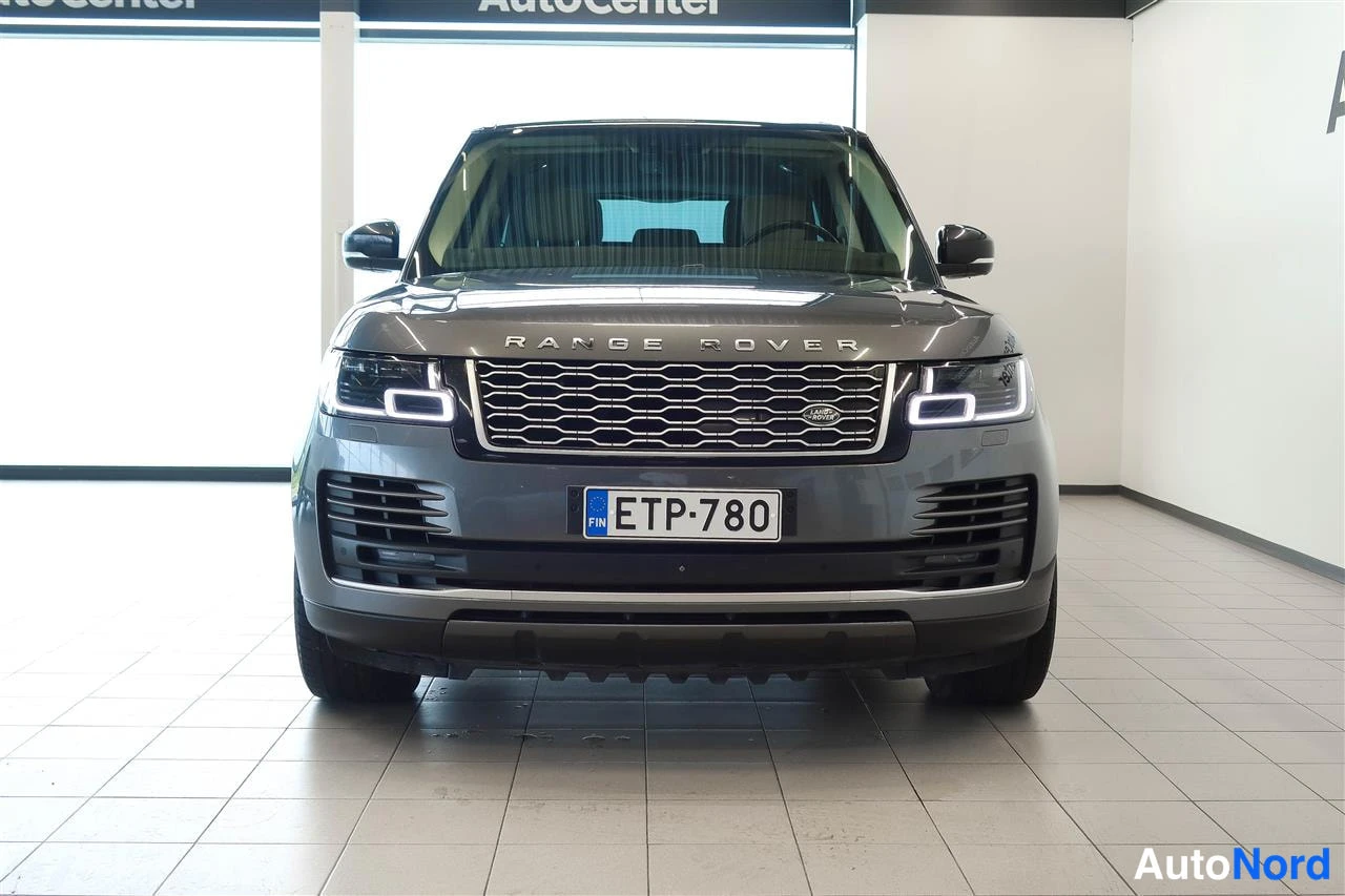 Edestä: Harmaan Range Rover -maasturin suora etunäkymä autotallin sisällä, rekisteritunnus.