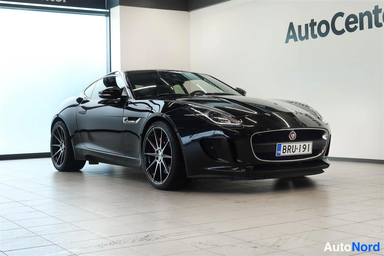 Etuviisto, nokka oikealle: Musta urheilucoupé kolmannelnekulmakuvassa etuosasta oikealle, rekisteritunnus, AutoCenter-showroom.