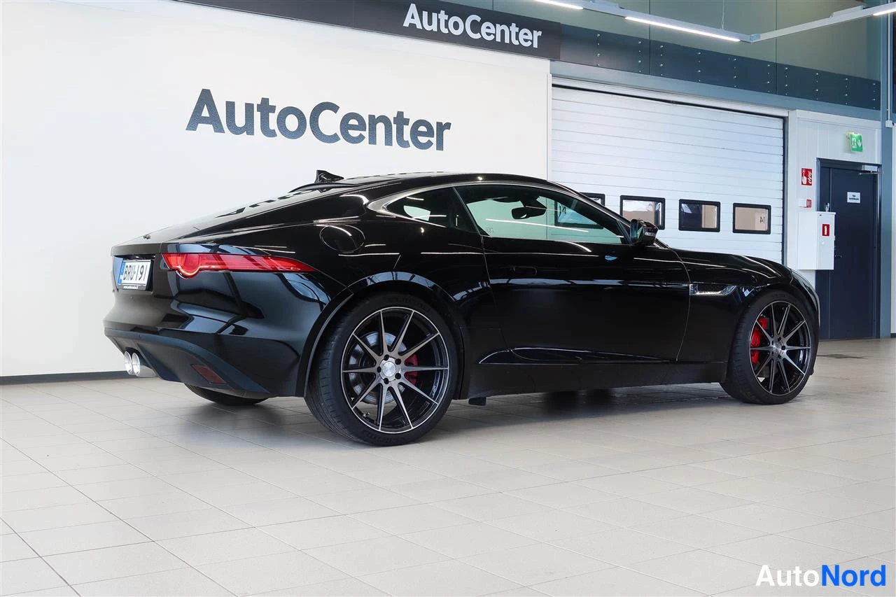 Takaviisto: Mustan coupé:n takaosa ja vasen kylki näkyvät AutoCenter-hallissa.