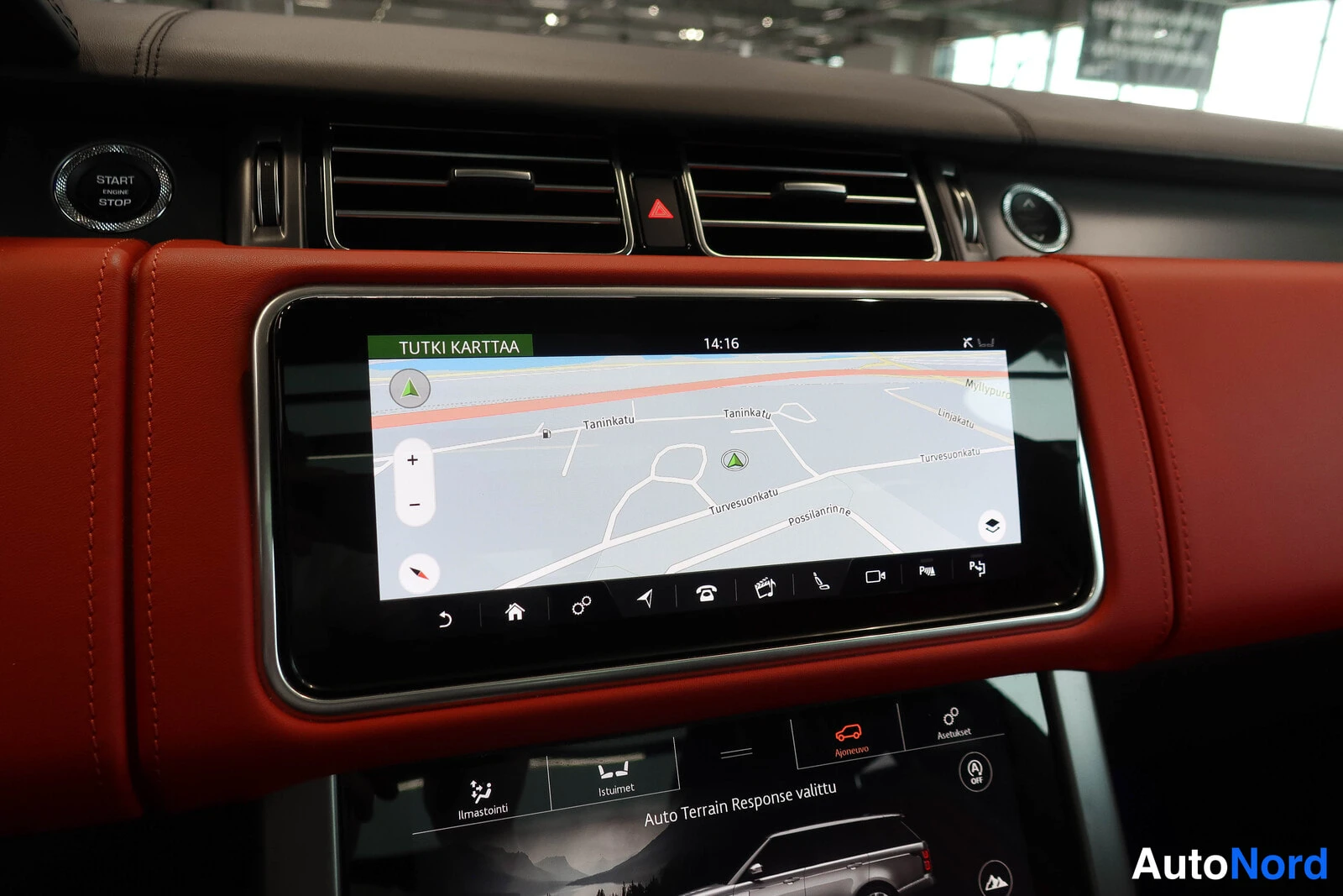 Muu: Kojelaudan kosketusnäyttö, jolla on näkyvissä navigointikartta ja teksti 'TUTKI KARTTAA' sekä 'Auto Terrain Response valittu'.