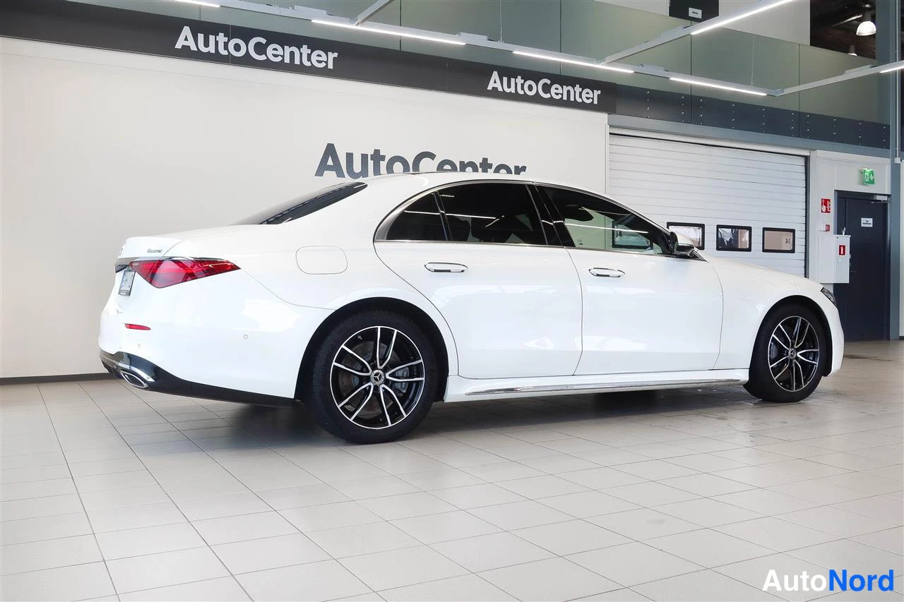 Takaviisto: Valkoinen sedan takaa kolmasosa-kulmasta AutoCenter-hallissa.