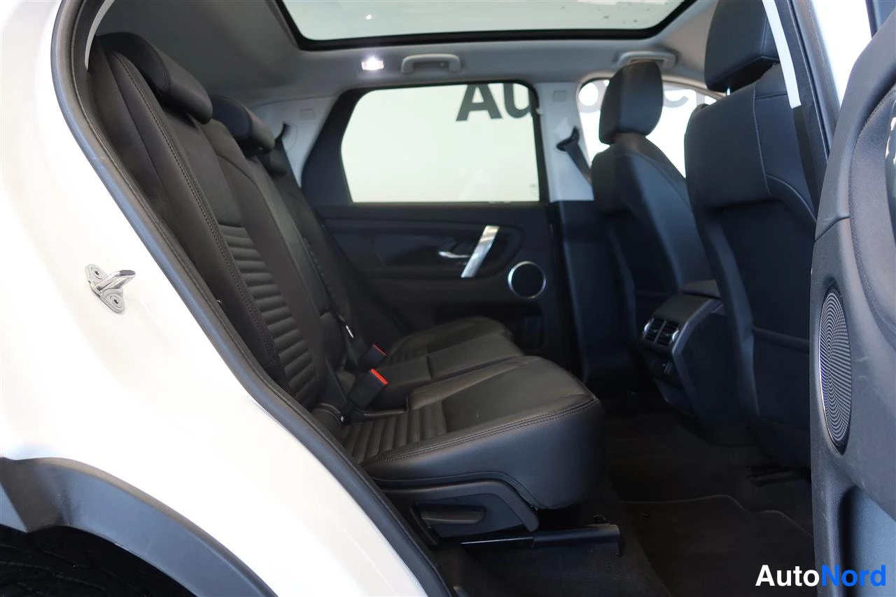 Muu: Takaistuimet autosta sivusuunnassa kuvattuna: musta penkki, keskinäsikäärme ja panoraamakatto näkyvät, valkoinen kori.