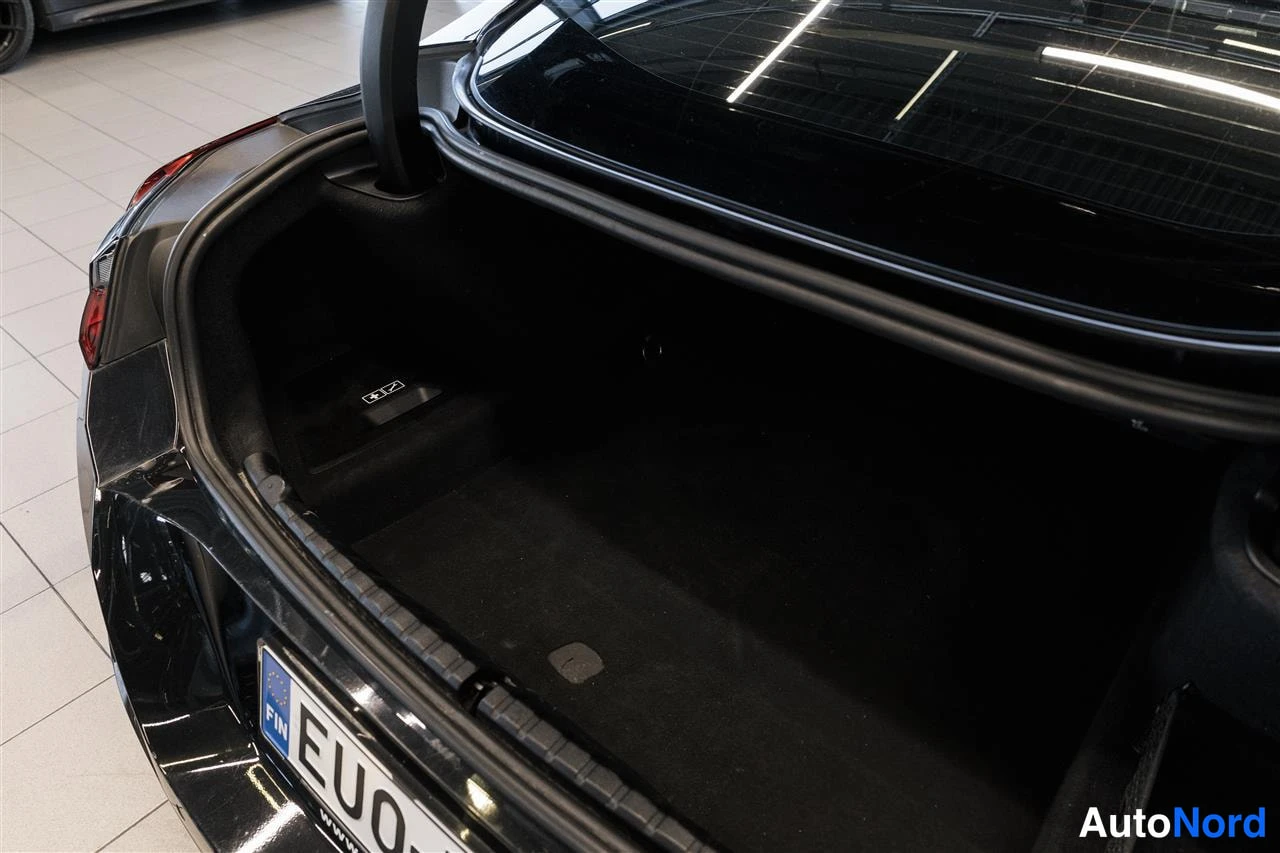 Takaa: Auki pidetty tavaratila mustassa autossa, tukeva kangasvöki tyhjällä.
