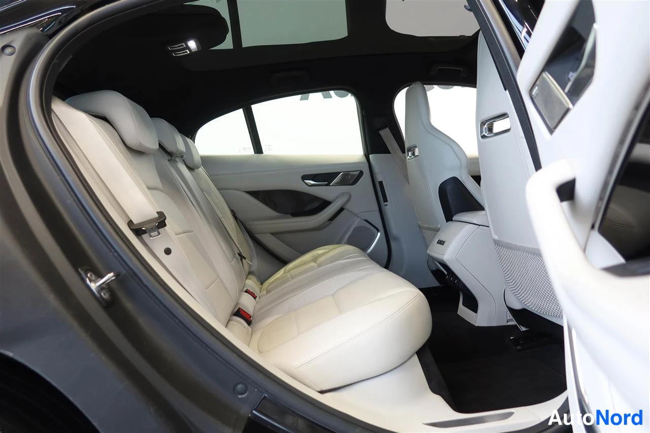 Muu: Takapenkki avatusta oikeasta takavestä: kolme henkilöä istuva penkki vaalealla nahalla, kaksi ISOFIX-kiinnikettä ja panoraamakaton lasiosia.