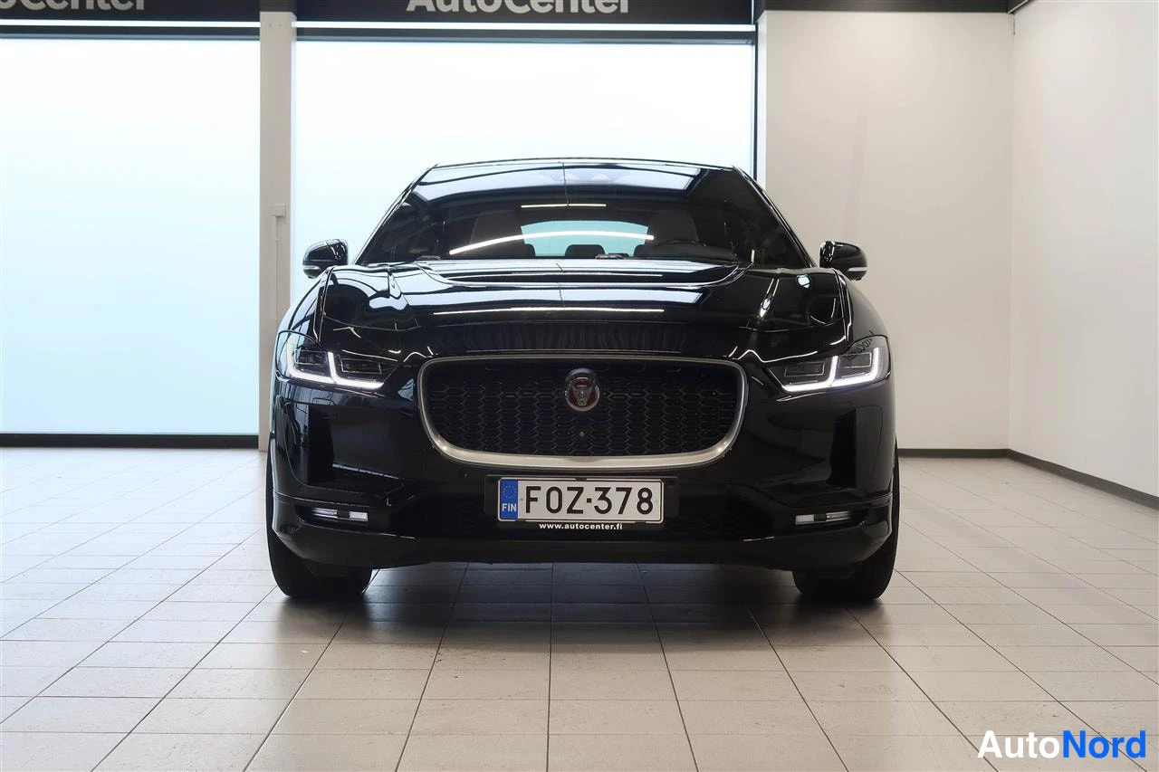 Edestä: Etukatselma mustasta Jaguar I-Pacesta autosalissa, rekisteritunnukseltaan F0Z-378.