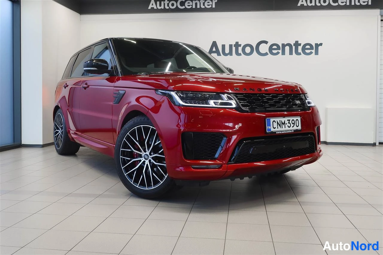 Etuviisto, nokka oikealle: Punainen Land Rover Range Rover Sport nokka oikealle kolmasosan kuvassa näyttelytilassa.