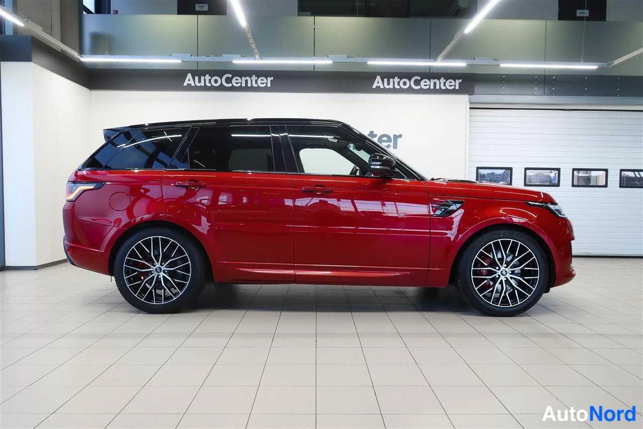 Takaviisto: Punaisen Land Rover Range Rover Sportin takasivukolmasosan sivunäkymä näyttelytilassa.