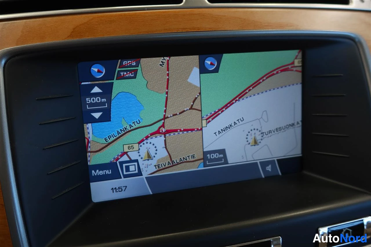 Yksityiskohta: Auton kojelaudan navigointiruutu näyttää karttaa GPS- ja TMC-merkeillä, kello 11:57.