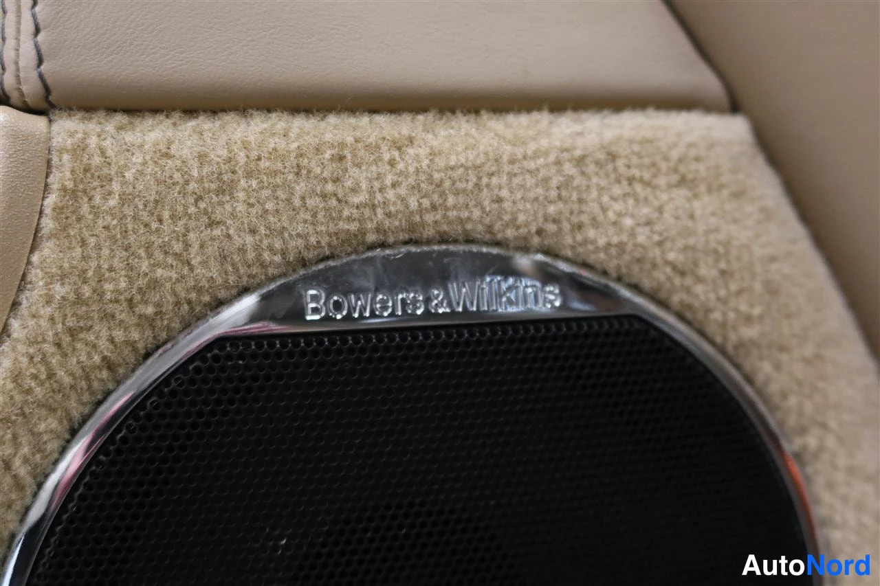 Muu: Beige mattapintainen kaiuttimen alustus, jossa tekstitetty Bowers & Wilkins -merkintä.