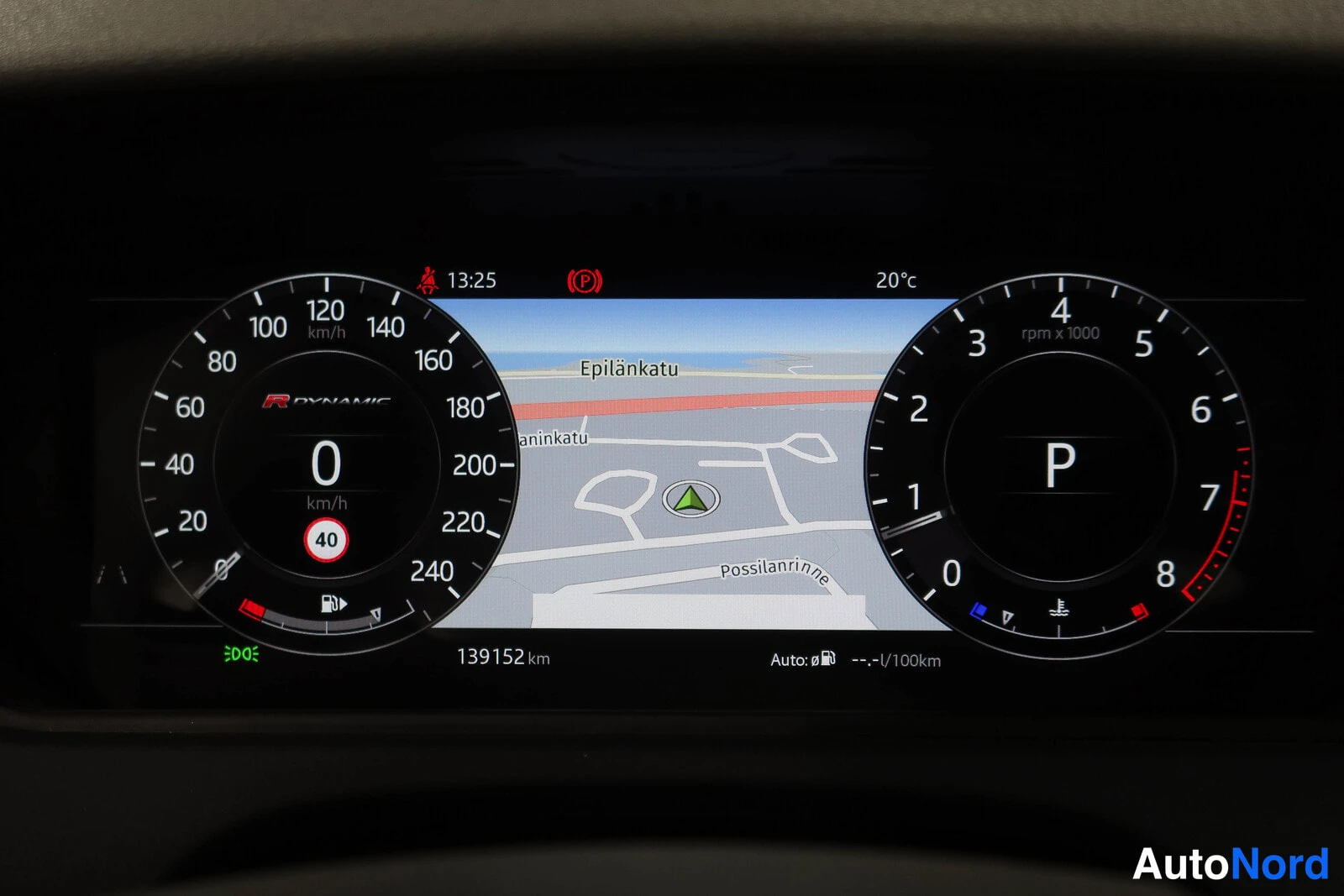 Yksityiskohta: Digitaalinen mittaristo: R-DYNAMIC-merkintä, nopeus 0 km/h, vaihde P, ajomatka 139152 km, ulkolämpötila 20 °C ja kartta (Epilänkatu, Possilannrinne).