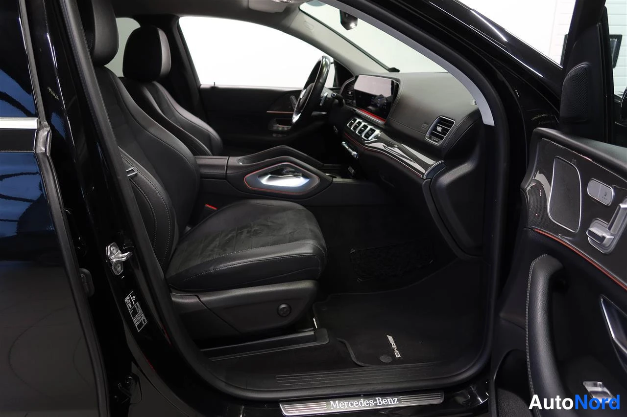 Muu: Avaamalla etuovella kuvattu ajoneuvon etuosa ja etupenkit, mustat nahkaistuimet, AMG-lattiamatto ja Mercedes-Benz-kynnyslistat.