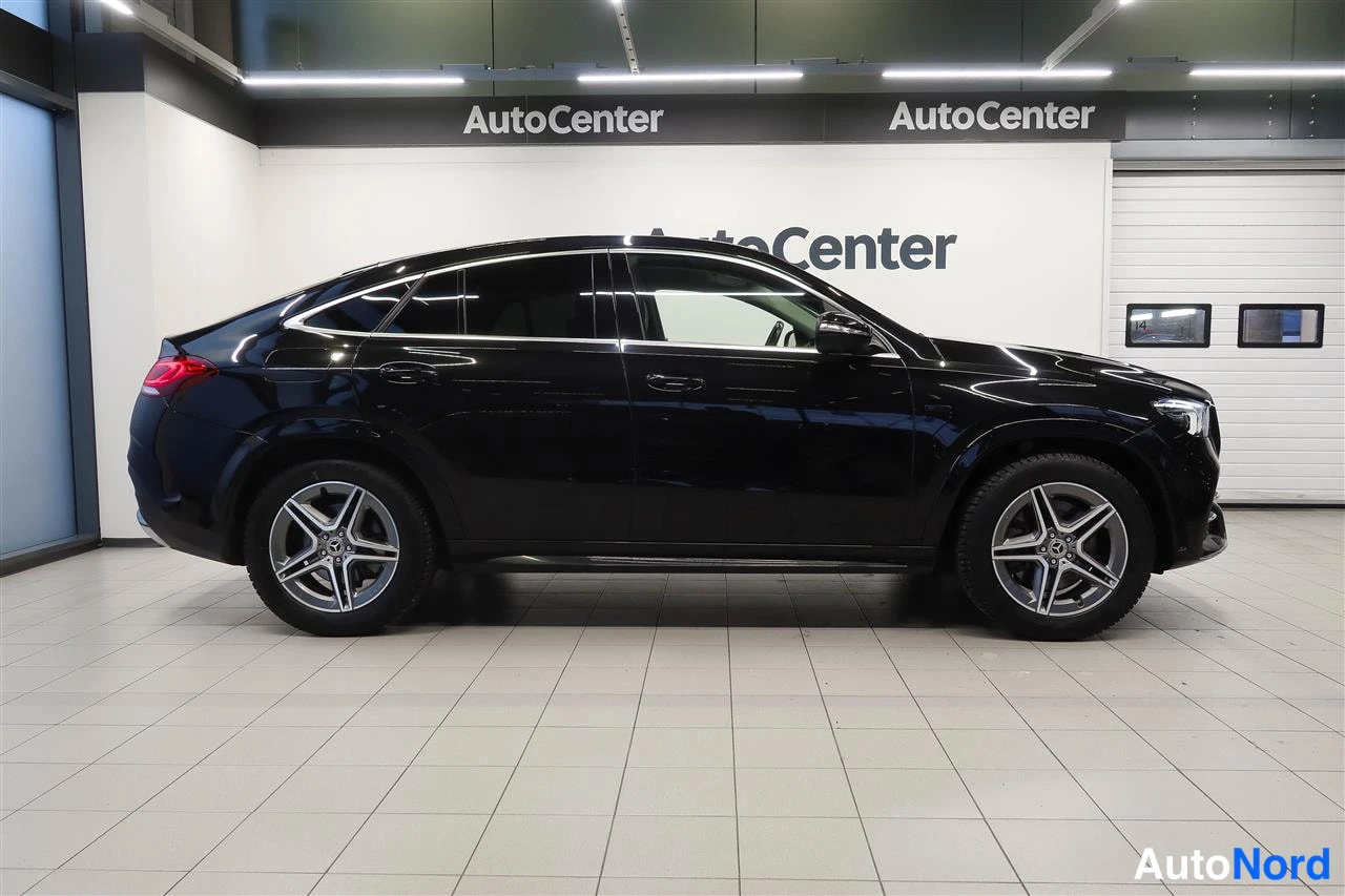 Sivulta: Musta Mercedes-Benz GLE Coupé sivulta vasemmalta, autonäyttämön lattialla.