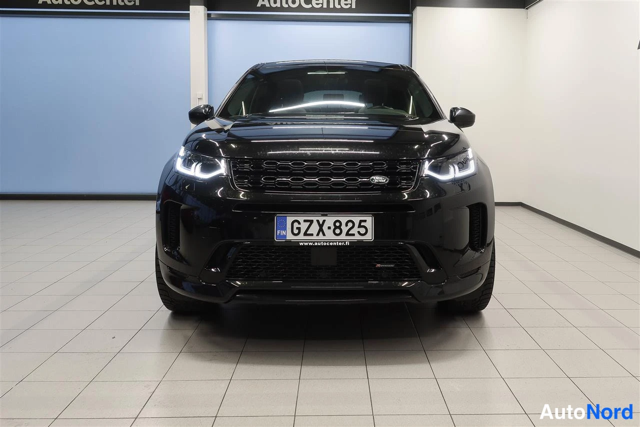 Edestä: Suora etukuva mustasta Land Rover Discovery Sportista, rekisteri, Autocenter-tilassa.