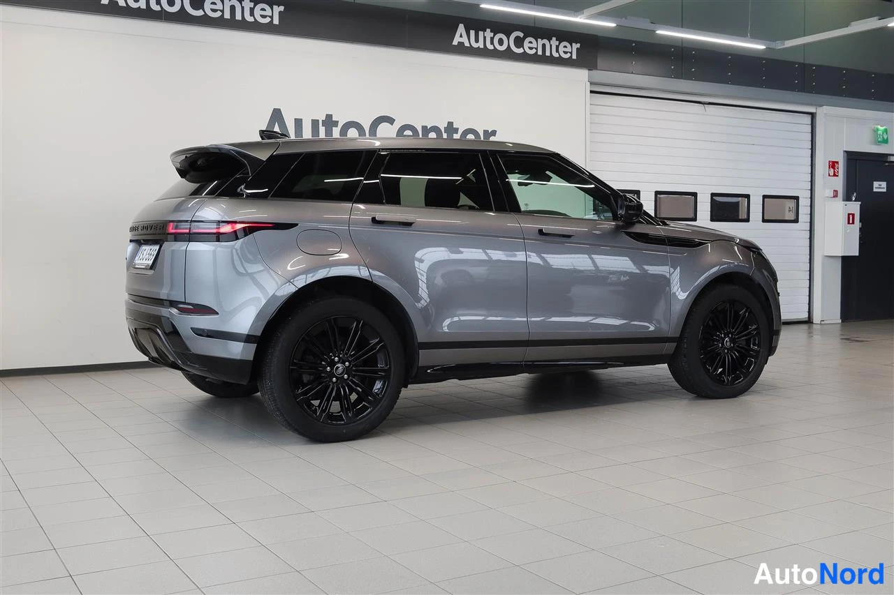 Takaviisto: Hopeanharmaa Range Rover Evoque takasivukulmasta sisätiloissa, mustat vanteet.