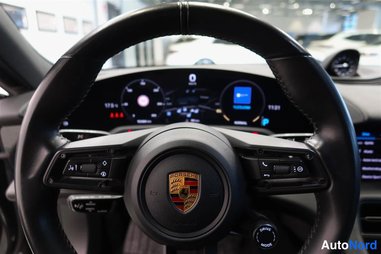 Muu: Ohjauspyörän keskus lähikuvassa: Porsche-merkki ja monitoiminappulat