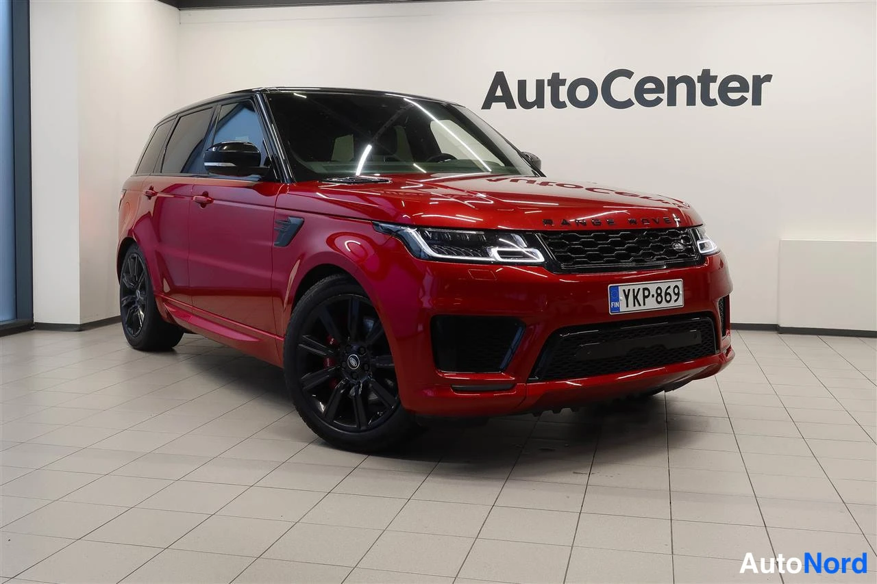 Etuviisto, nokka oikealle: Punainen Land Rover Range Rover Sport etuviistossa oikealta kuvaus­kulmalta, mustat vanteet ja musta katto.