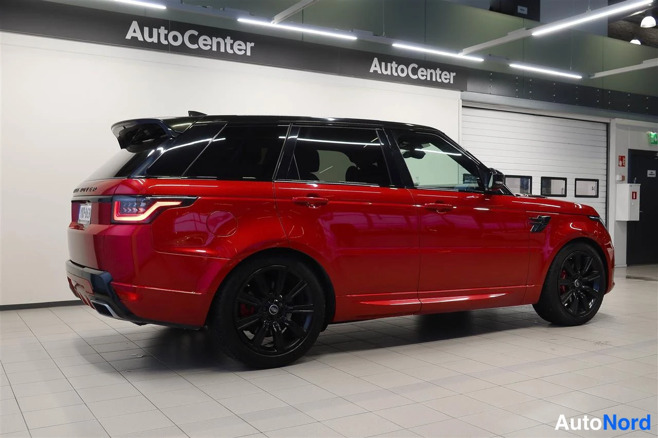 Takaviisto: Punainen Range Rover Sport takakulmakuvassa sisätiloissa, musta katto ja mustat vanteet