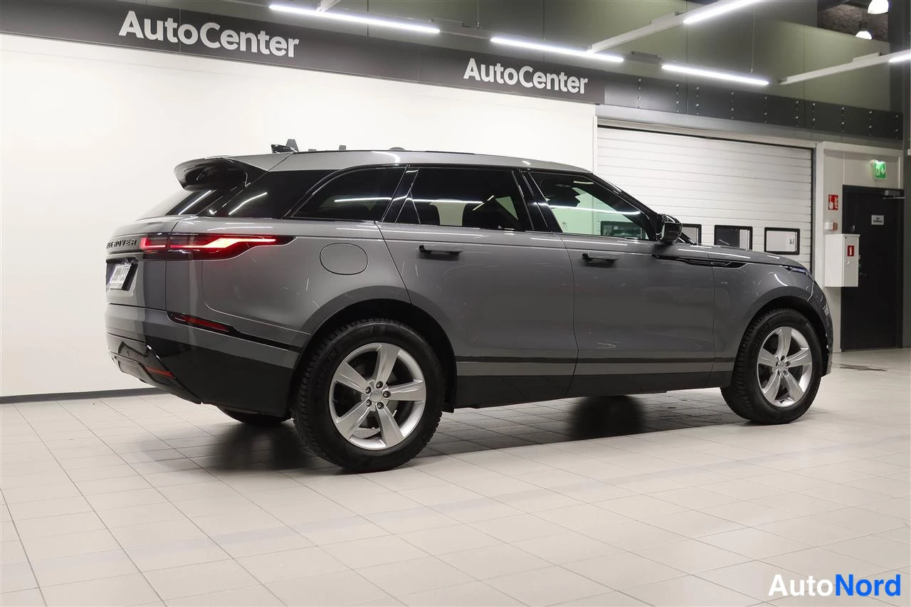Takaviisto: Land Rover Range Rover Velar, harmaa, takakulmaisträjätä sisätiloissa, perä vasemmalla.