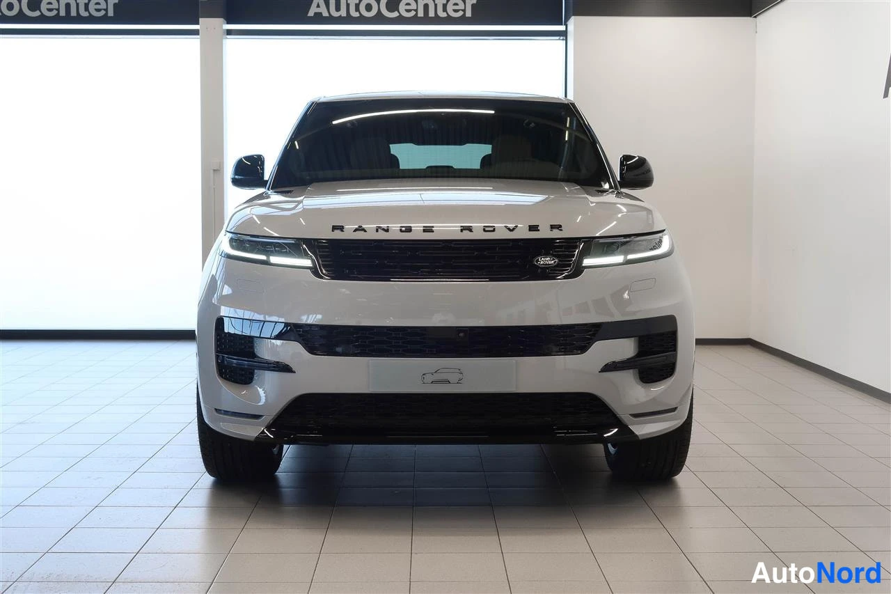 Edestä: Etisuoraan kuvattu hopeanharmaa Range Rover Sport, johon näkyvät etumoitus ja Range Rover -teksti.