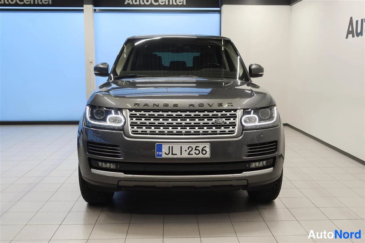 Edestä: Land Rover Range Roverin etunäkymä suoraan edestä, rekisteritunnus JL I-256 ja etupyörät näkyvissä showroomissa.
