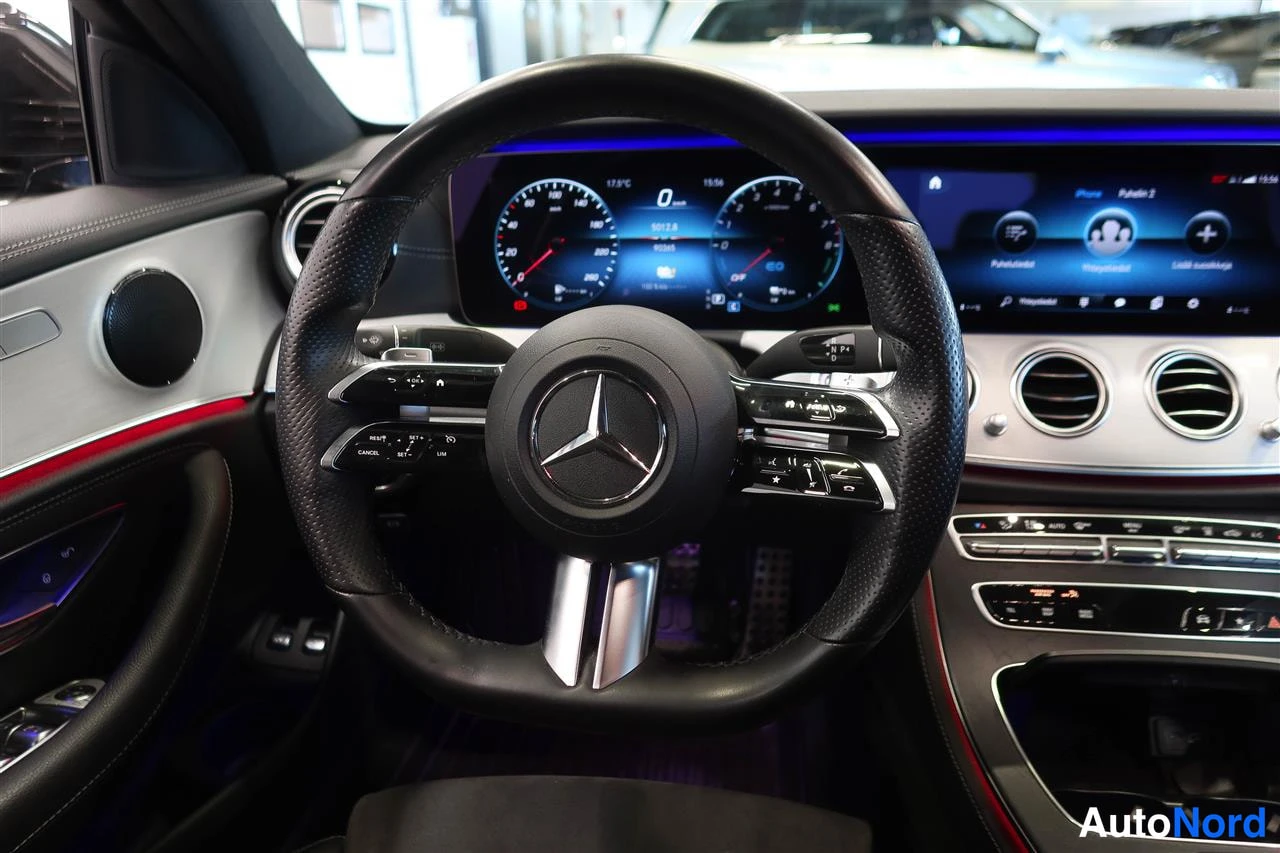 Muu: Ohjauspyörän ja kojelaudan näyttöjen lähikuva: Mercedes-tähti, digitaalinen mittaristo ja infotainment-näyttö.