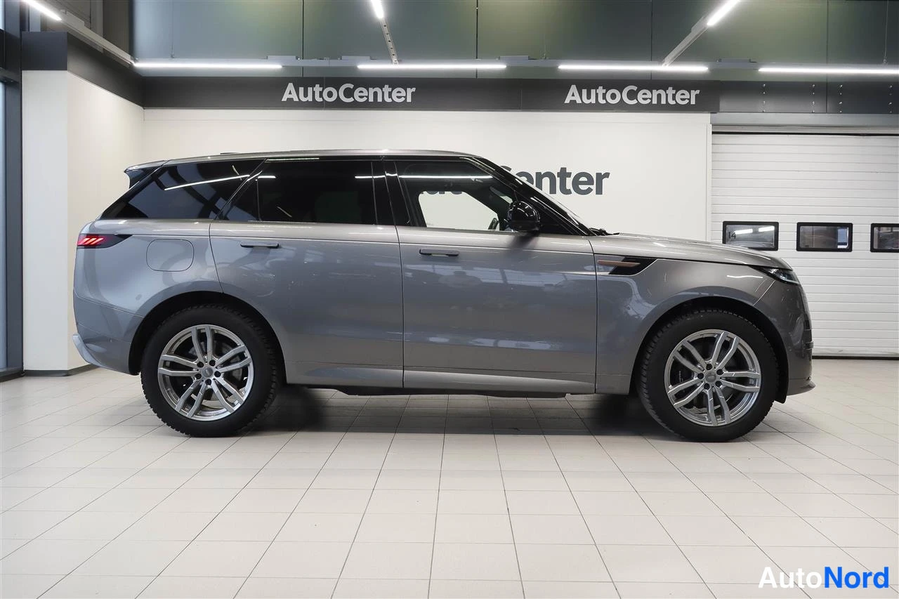 Sivulta: Harmaa Range Rover Sport sivuprofiilista vasemmalta, AutoCenter-hallissa.