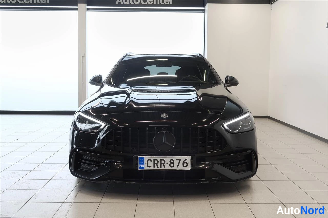 Edestä: Mustan farmariauton etunäkymä suoraan edestä, AutoCenter-hallissa.