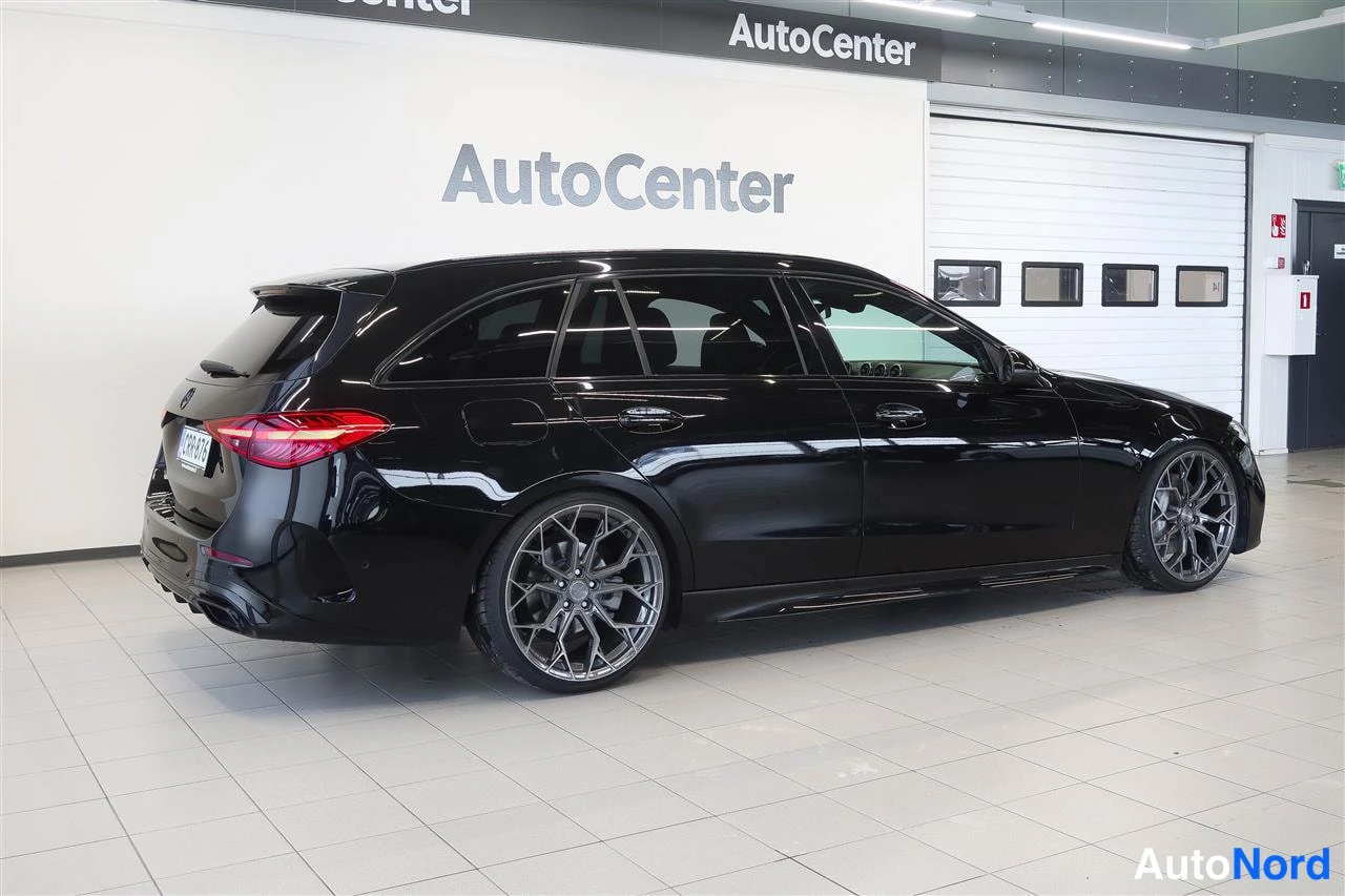 Takaviisto: Musta farmari kolmesta neljänneksestä takaa vasemmalta, AutoCenter-hallissa.