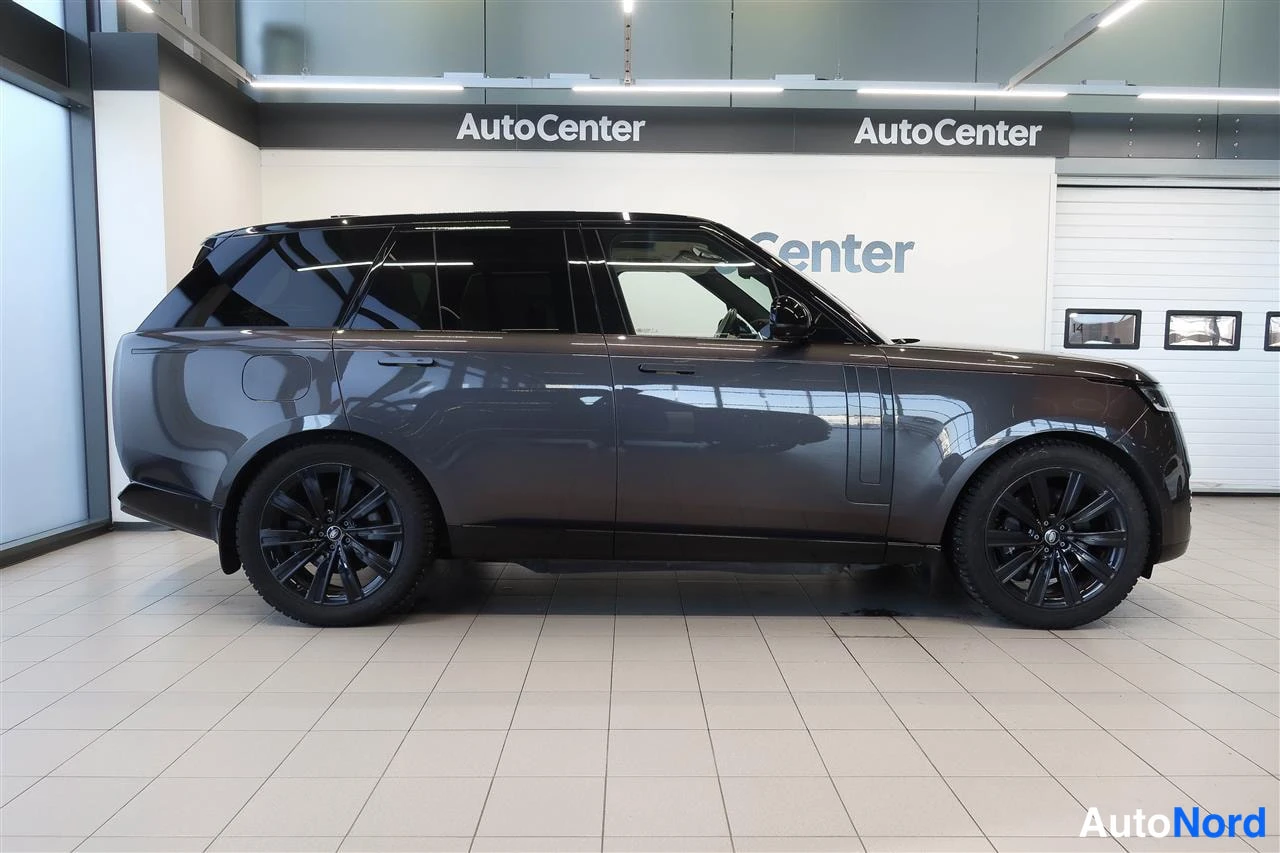 Sivulta: Tummanharmaa Range Rover sivulta vasemman kyljen suunnasta myyntitilassa.