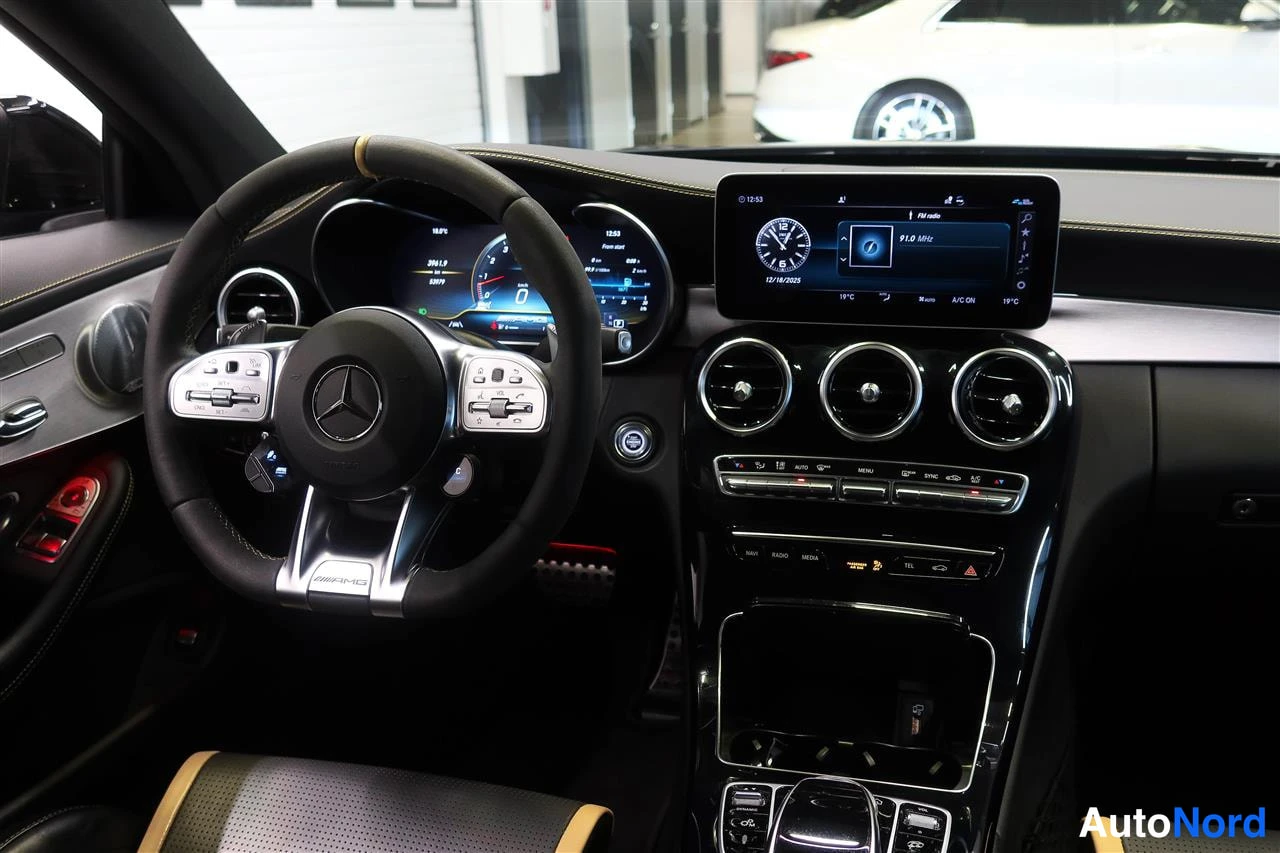Yksityiskohta: Ammattimainen kuvakulma Mercedes-Benzin ohjaamosta: AMG-ohjauspyörä, digitaalinen mittaristo ja keskinäyttö radio-ikkunalla.