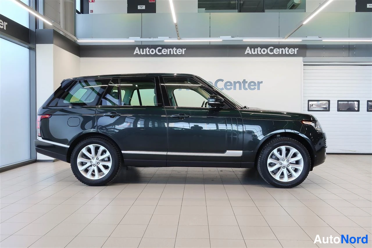 Sivulta: Land Rover Range Rover sivulta vasemmalta, koko kylki näkyvissä showroom-tilassa.