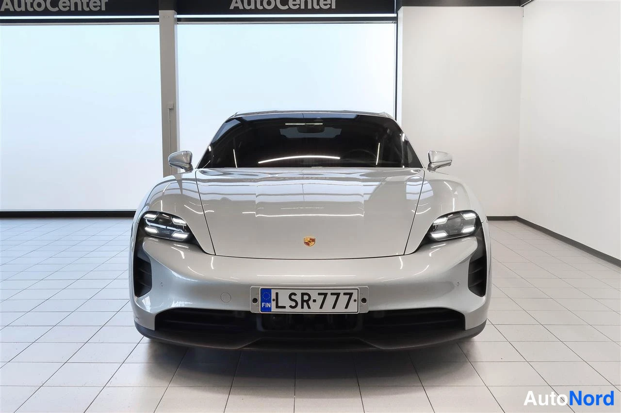 Edestä: Porsche Taycan suoraan edestä, rekisterikilpi, hopeanhohtoinen kori.