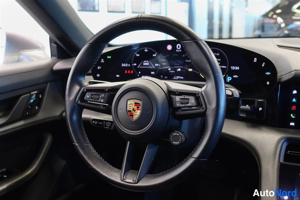 Muu: Porsche-ohjauspyörä lähikuvaana, taustalla digitaalinen mittaristo ja DRIVE MODE -kytkin.