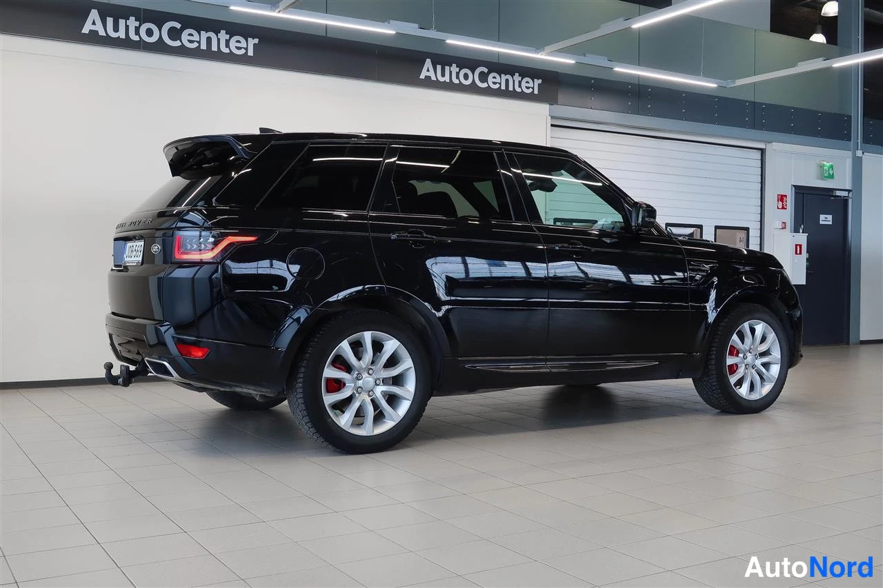 Takaviisto: Musta Land Rover Range Rover Sport takaviistosta sisätiloissa; näkyvissä perävaunun kytkin, takavalot ja hopeavanteet.