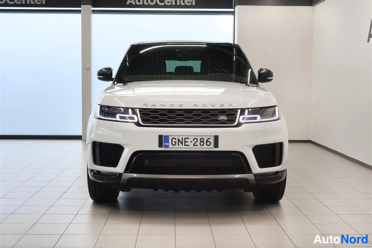 Edestä: Valkoisen Land Rover Range Rover Sportin etunäkymä myymälässä; etumoottoriteline ja Rekisteritunnus.