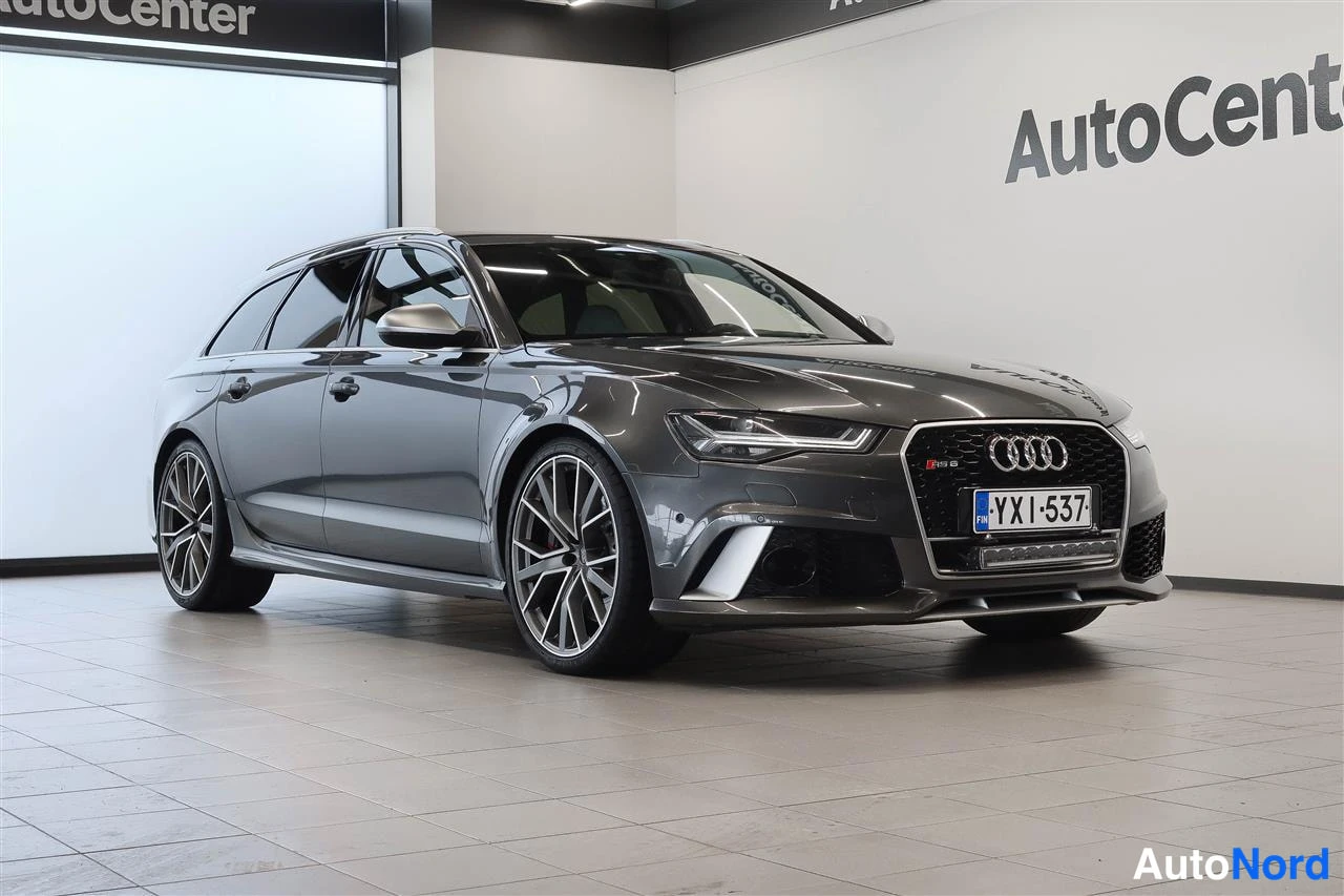 Etuviisto, nokka oikealle: Tummanharmaa Audi A6-farmari kolmesta neljäsosasta edestä oikealta, AutoCenter-hallissa, rekisteritunnus.