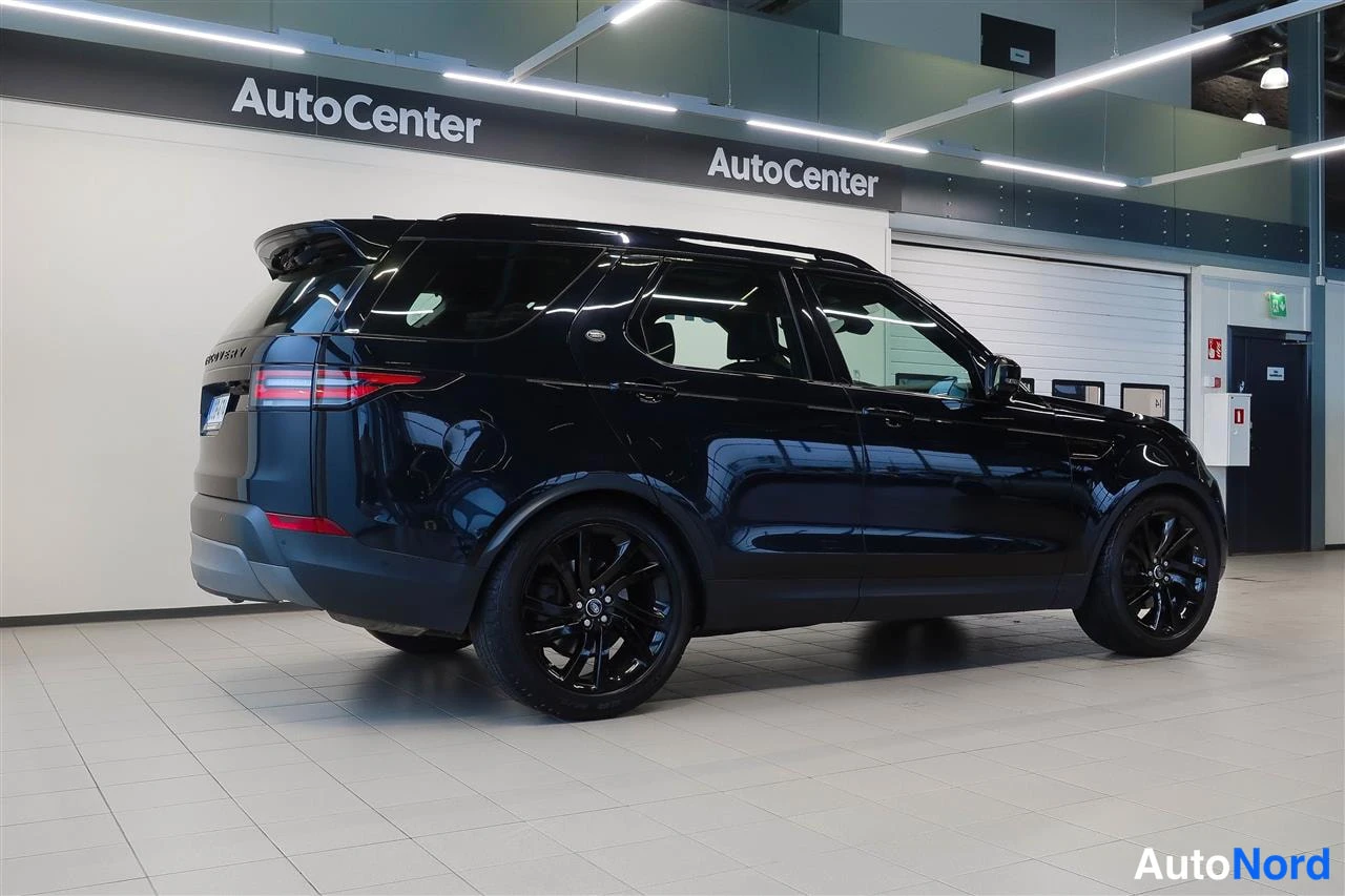 Takaviisto: Musta Land Rover -maasturi takaviistosta autonhallissa.
